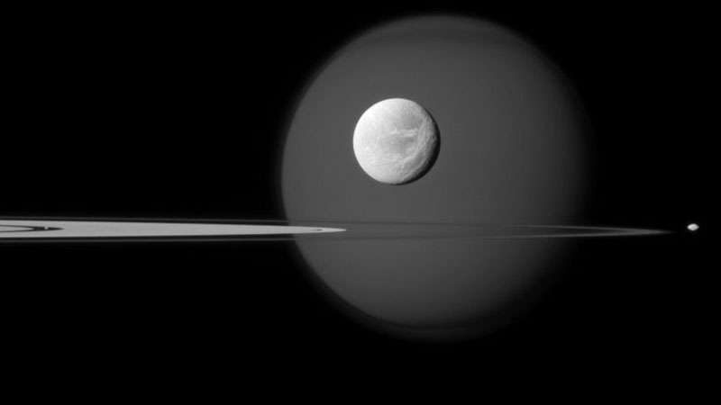 Кольца Сатурна и четыре его спутника слева направо Пан (в разрыве колец), Титан, Диона (на фоне Титана) и Пандора